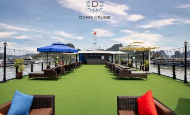 Relaxing cruise balcony overlooking Halong Bay with comfortable seating and vibrant cushions.