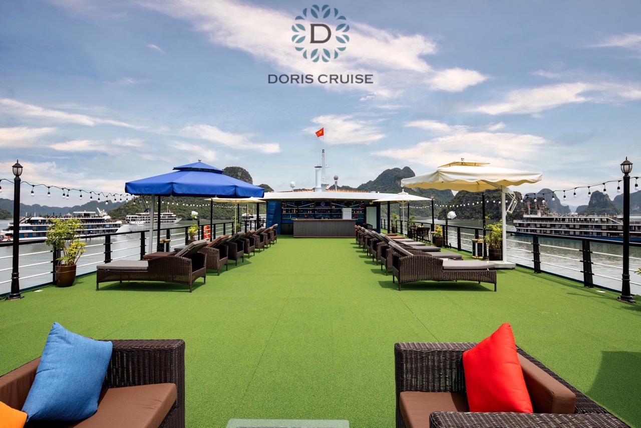 Relaxing cruise balcony overlooking Halong Bay with comfortable seating and vibrant cushions.
