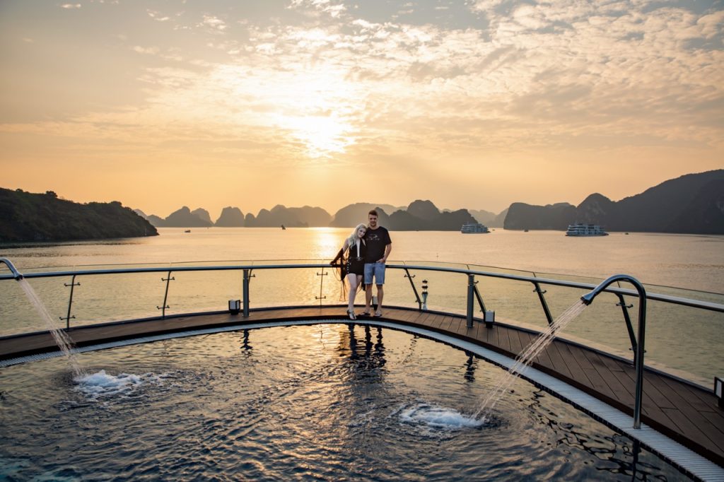 Relaxing ocean sunset cruise with couple at Halong Bay, Vietnam.