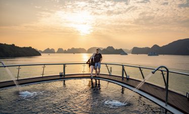 Relaxing ocean sunset cruise with couple at Halong Bay, Vietnam.