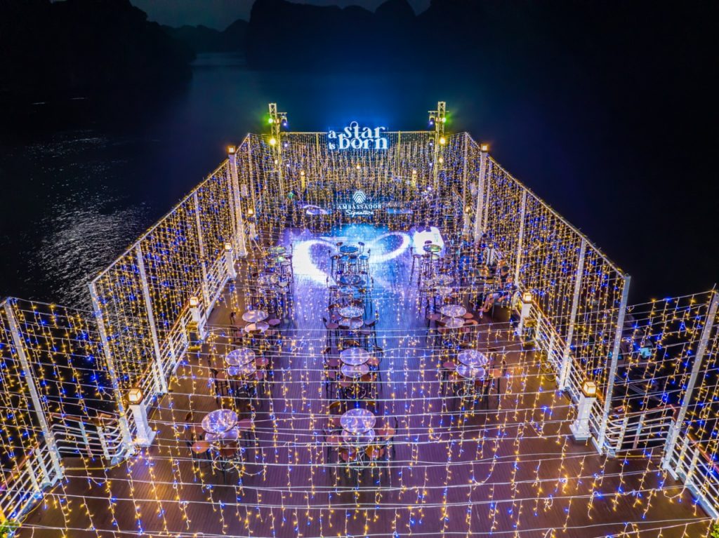 Stunning night scene of a luxury cruise deck illuminated with string lights, overlooking Halong Bay,.