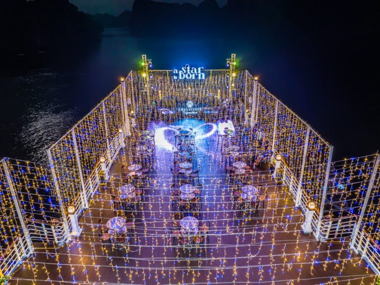 Stunning night scene of a luxury cruise deck illuminated with string lights, overlooking Halong Bay,.