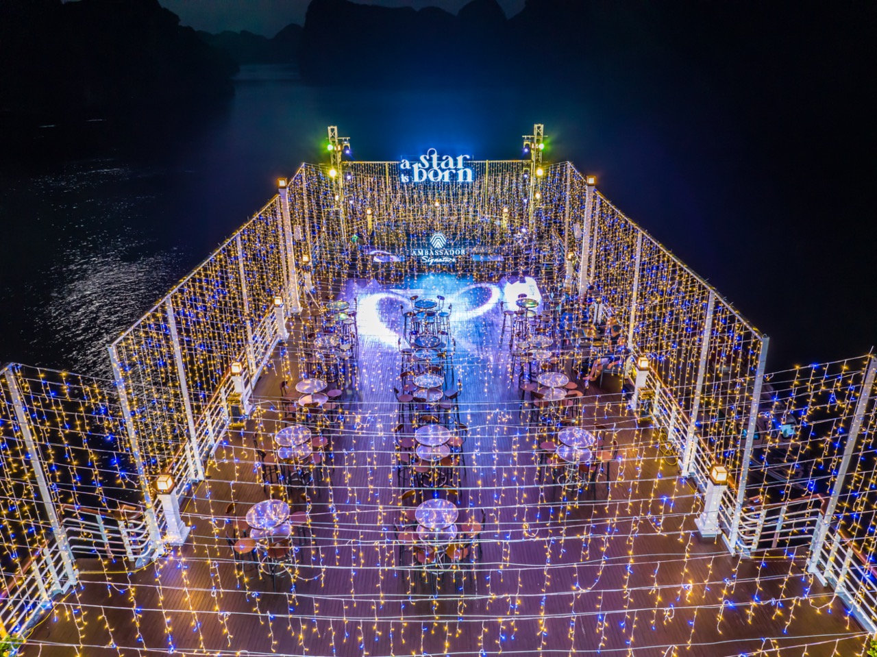 Stunning night scene of a luxury cruise deck illuminated with string lights, overlooking Halong Bay,.
