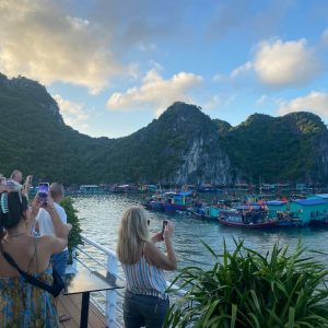 Travelers photograph a colorful floating village from the sundeck.