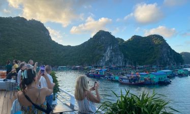 Halong Bay cruise balcony with scenic mountain views and tranquil waters.