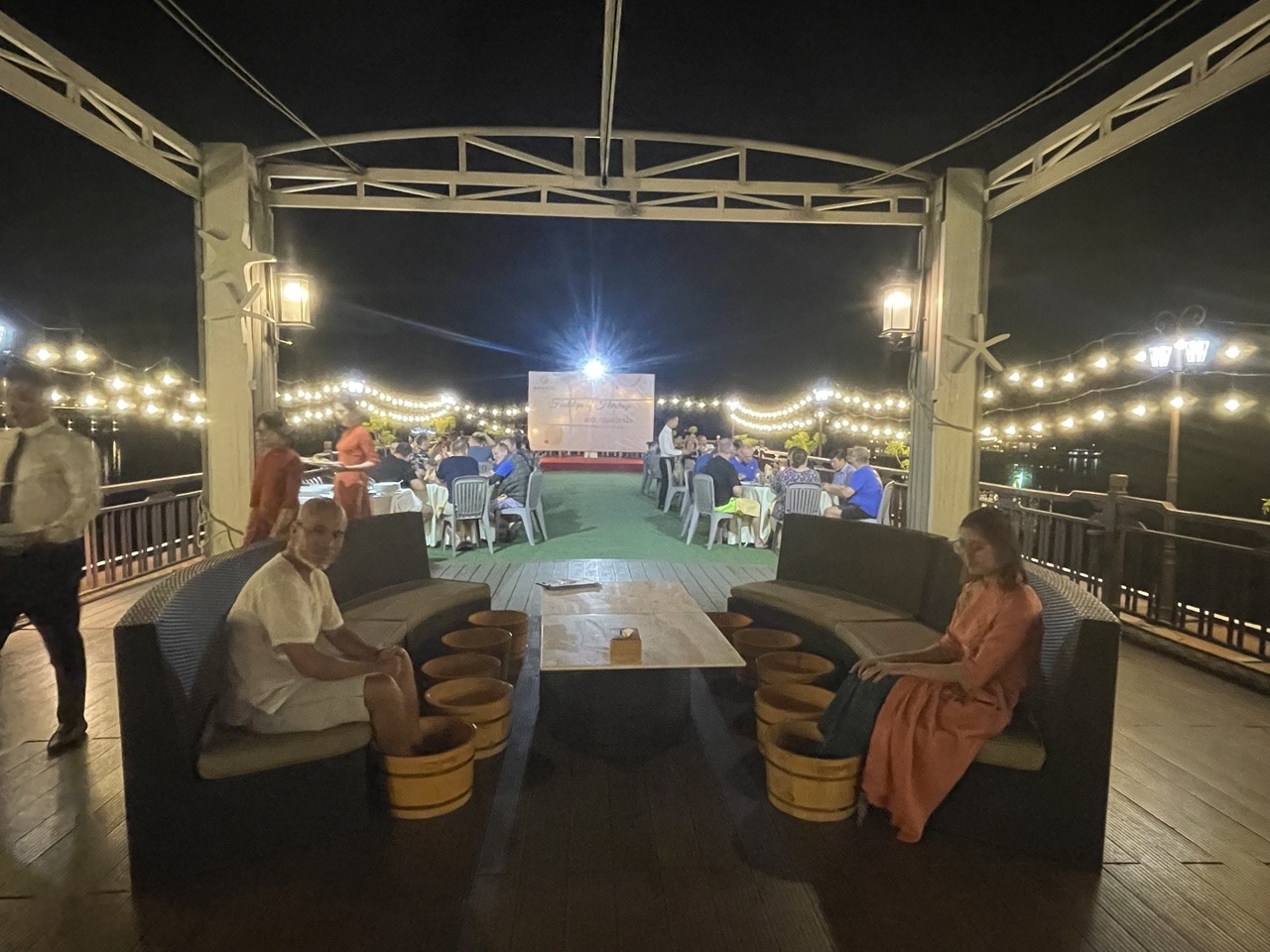 Relaxing night dinner on a rooftop with string lights in Vietnam, perfect for travel and tour experiences.