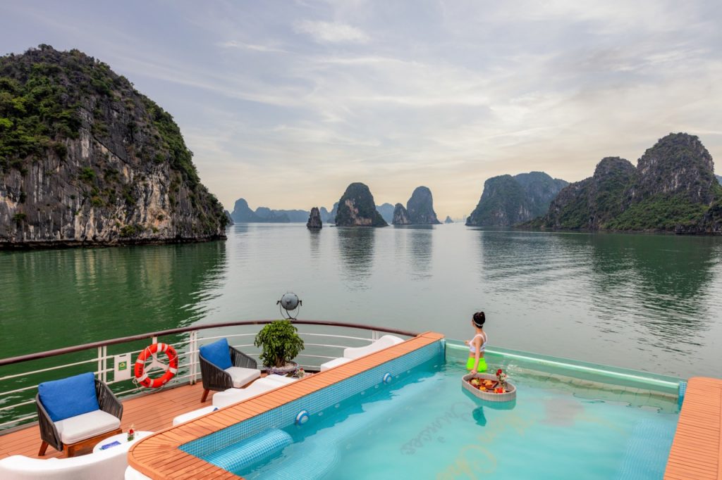 Stunning view of Halong Bay with calm waters and limestone karsts from a cruise balcony.
