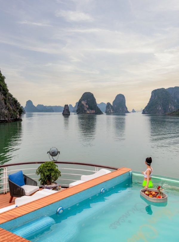 Stunning view of Halong Bay with calm waters and limestone karsts from a cruise balcony.