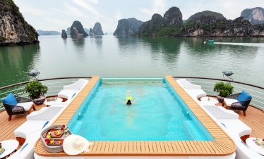Stunning view of Halong Bay from a cruise balcony with limestone karsts and calm waters, perfect for.
