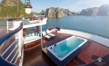 Luxurious cruise balcony overlooking Halong Bay with scenic limestone karsts and calm waters.