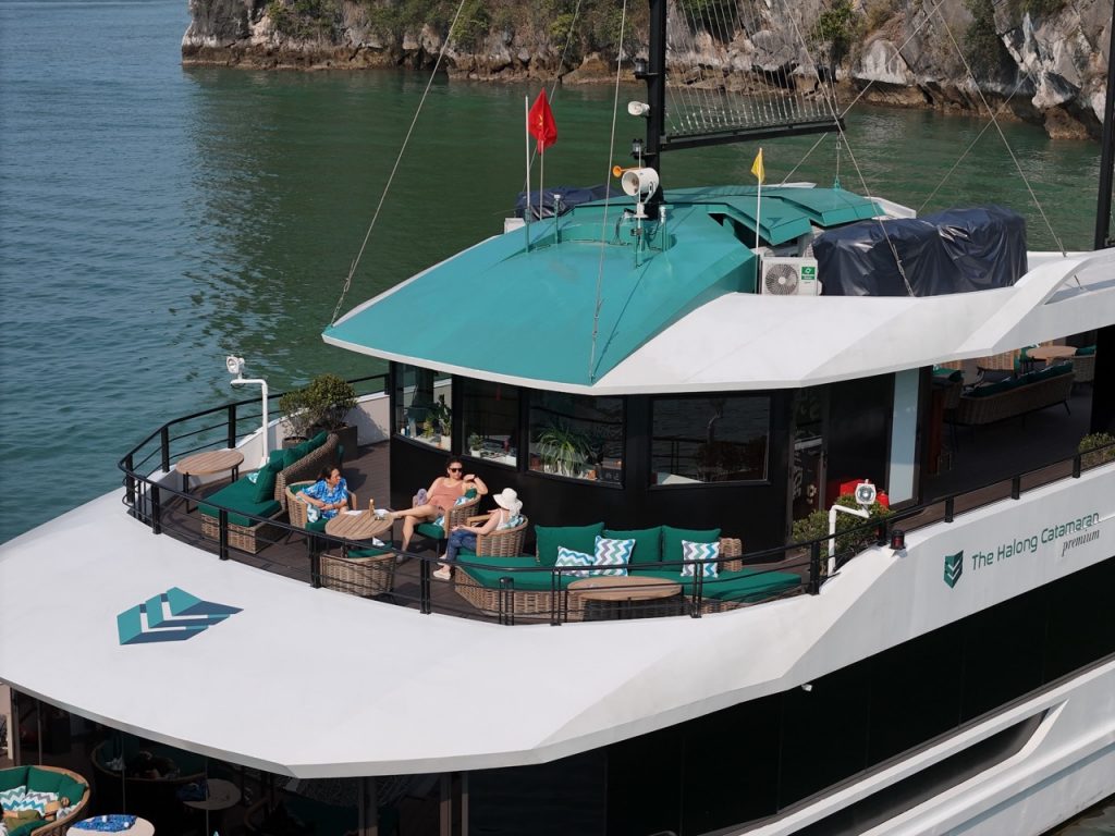 Lan Ha Bay cruise balcony with relaxing passengers enjoying scenic views.