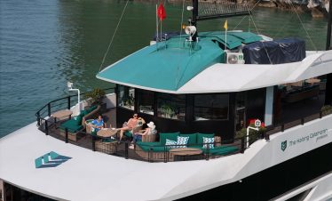 Lan Ha Bay cruise balcony with relaxing passengers enjoying scenic views.