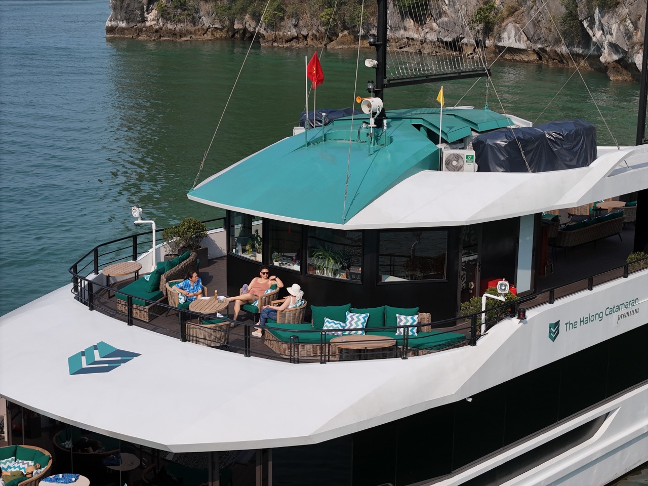 Lan Ha Bay cruise balcony with relaxing passengers enjoying scenic views.