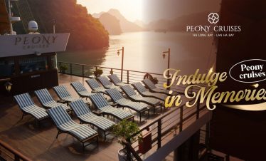 Stunning view of Halong Bay from cruise balcony with relaxing lounge chairs at sunset.