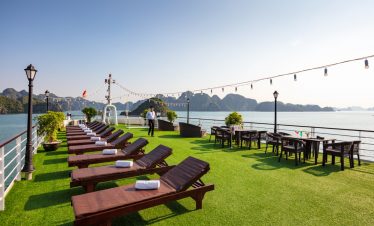 Relaxing Halong Bay cruise deck with lounge chairs and panoramic water views for a memorable travel.