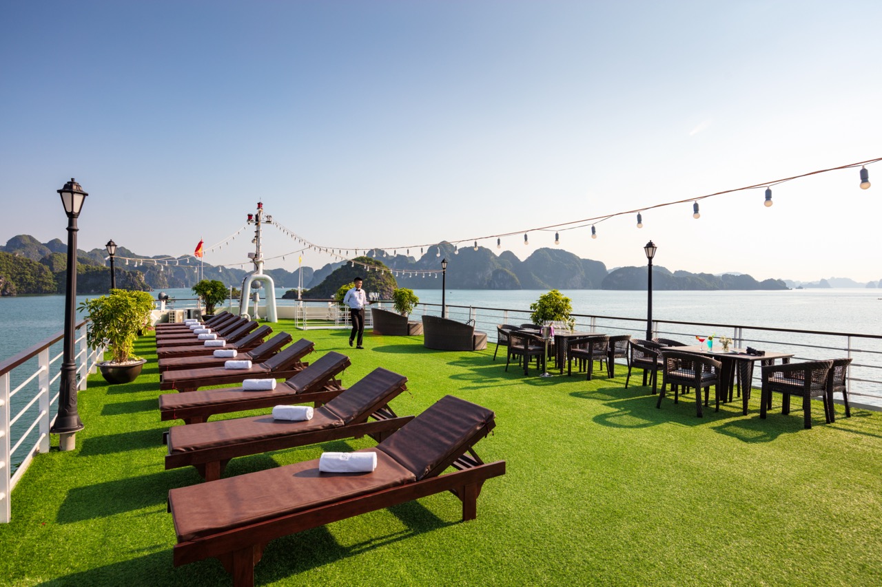 Relaxing Halong Bay cruise deck with lounge chairs and panoramic water views for a memorable travel.