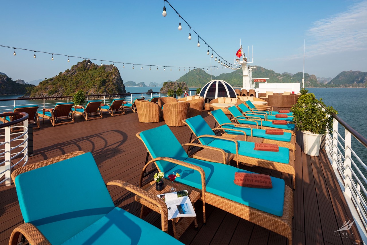 Relaxing cruise deck with sun loungers overlooking Halong Bay, Vietnam.