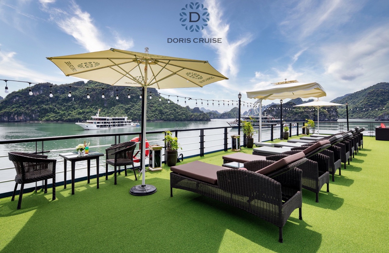 Stunning Halong Bay cruise balcony with panoramic views, luxurious seating, and vibrant natural scen.