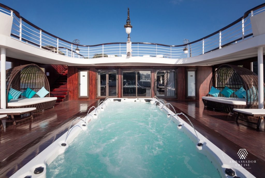Luxury Halong Bay cruise balcony with relaxing hot tub, offering stunning views of the bay and seren.