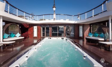 Luxury Halong Bay cruise balcony with relaxing hot tub, offering stunning views of the bay and seren.
