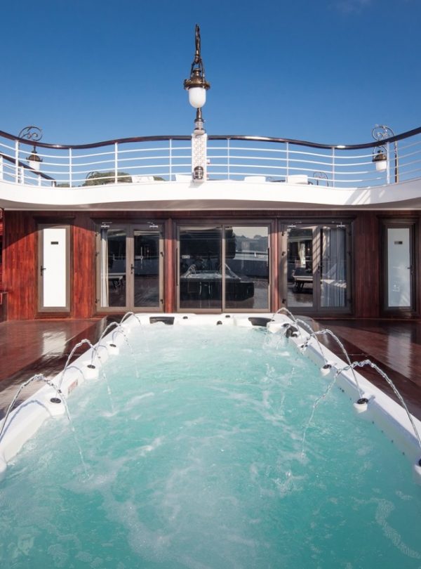 Luxury Halong Bay cruise balcony with relaxing hot tub, offering stunning views of the bay and seren.