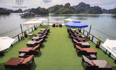 Relaxing cruise deck with loungers overlooking Halong Bay's stunning limestone karsts - ViettrendTou.