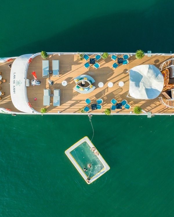 Aerial view of luxury cruise boat on Lan Ha Bay with sun deck and seating area, perfect for relaxing.