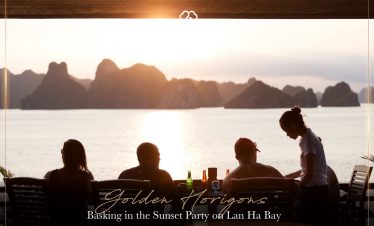 People enjoying sunset drinks on cruise balcony in Lan Ha Bay, Vietnam, during golden hour.