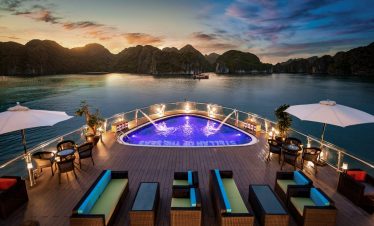 Luxurious yacht deck with infinity pool overlooking stunning bay at sunset, vacation escape.