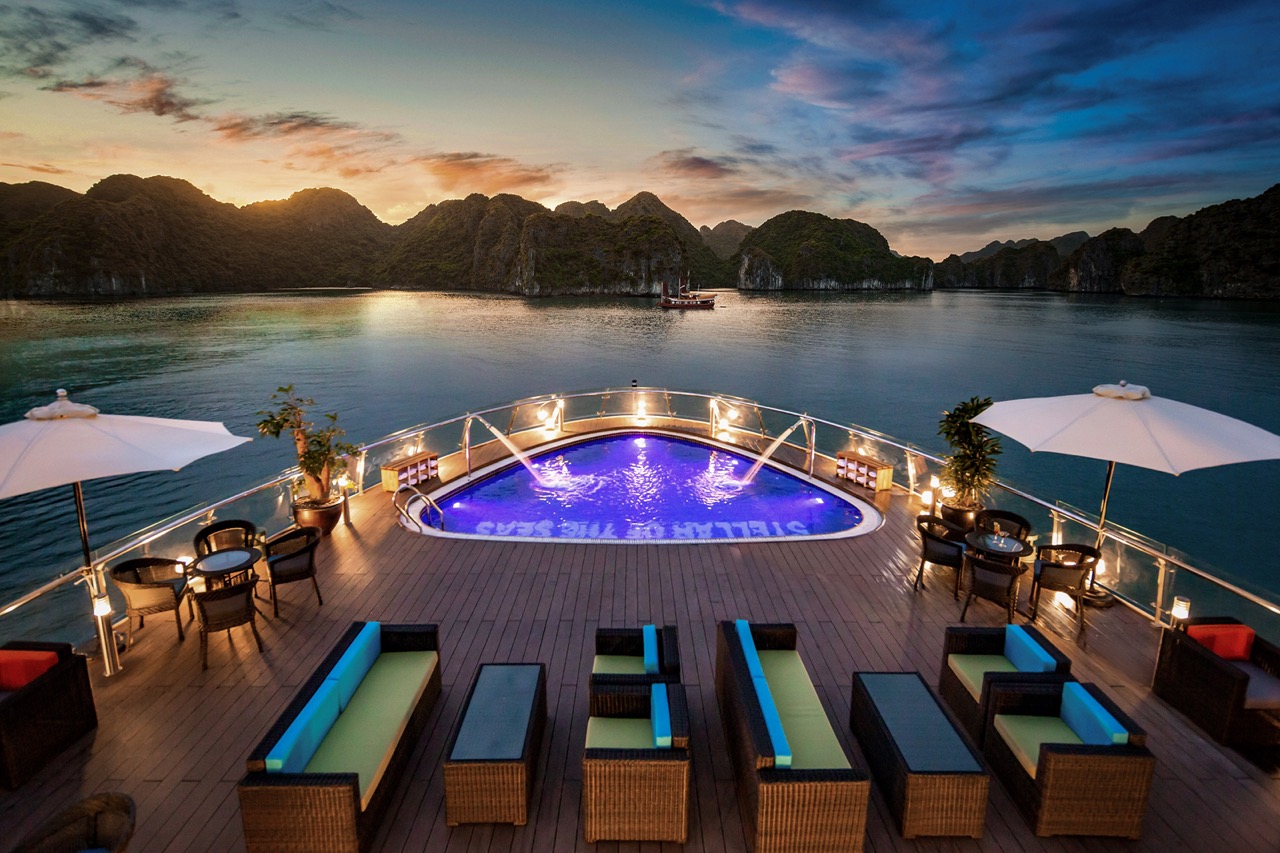 Luxurious yacht deck with infinity pool overlooking stunning bay at sunset, vacation escape.