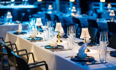Luxurious cruise dining scene with table settings and ambient lighting on Halong Bay.