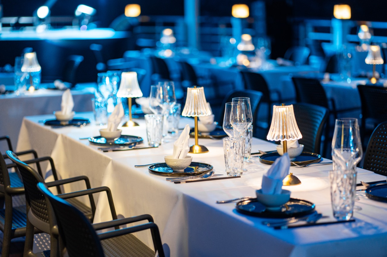 Luxurious cruise dining scene with table settings and ambient lighting on Halong Bay.