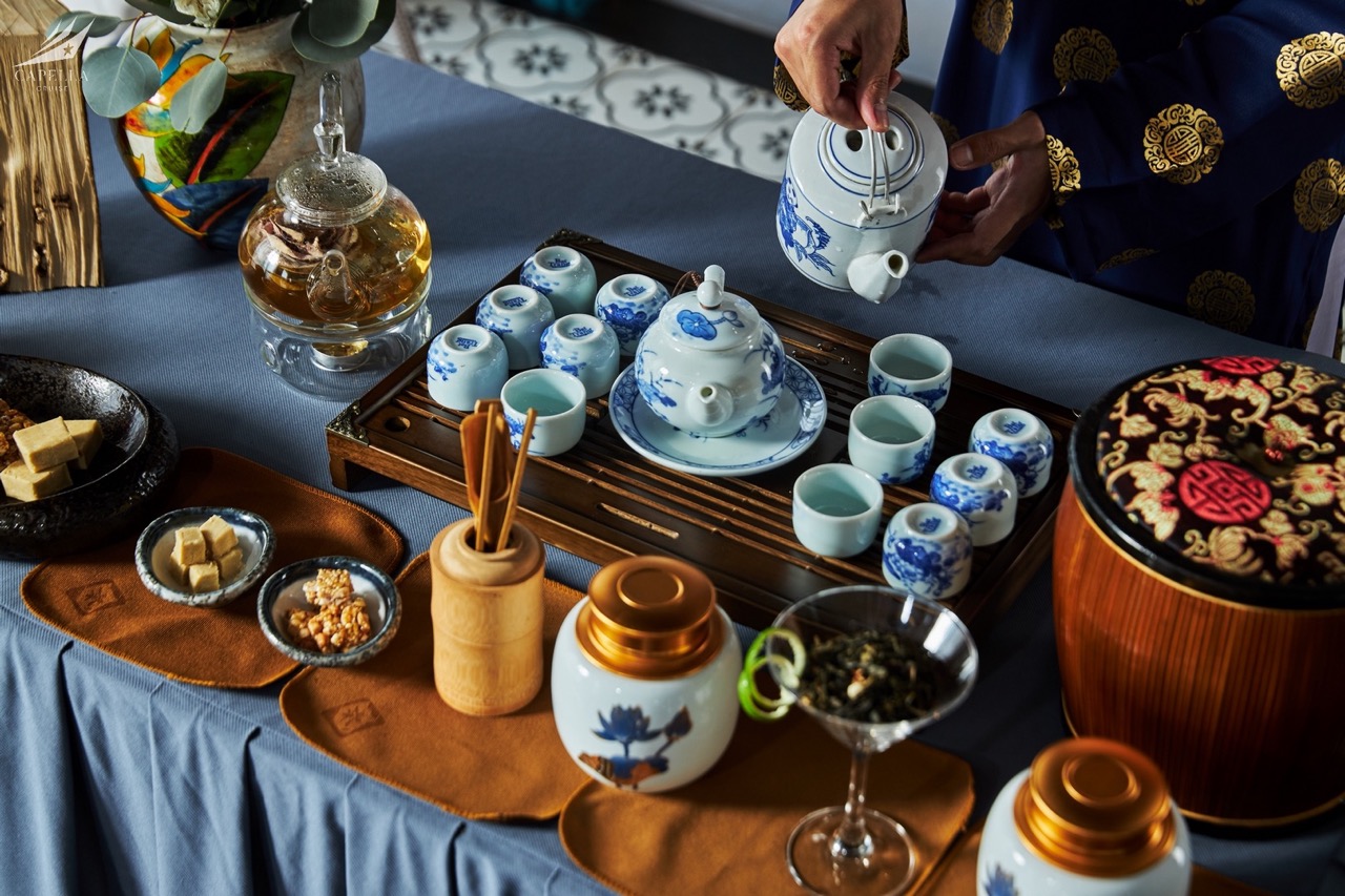 Elegant traditional Vietnamese tea setting with blue and white porcelain, tea and snacks.