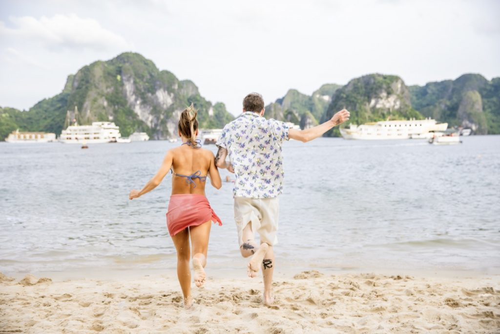 Beautiful couple enjoying Halong Bay cruise on a sunny day.