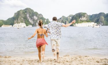 Beautiful couple enjoying Halong Bay cruise on a sunny day.
