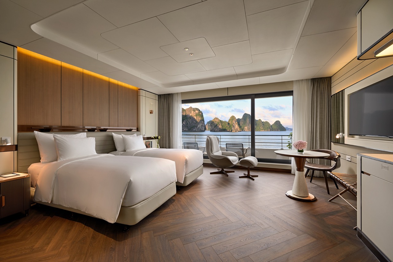 Luxurious ocean-view hotel room with modern design, king-size beds, and a panoramic balcony view of limestone islands.