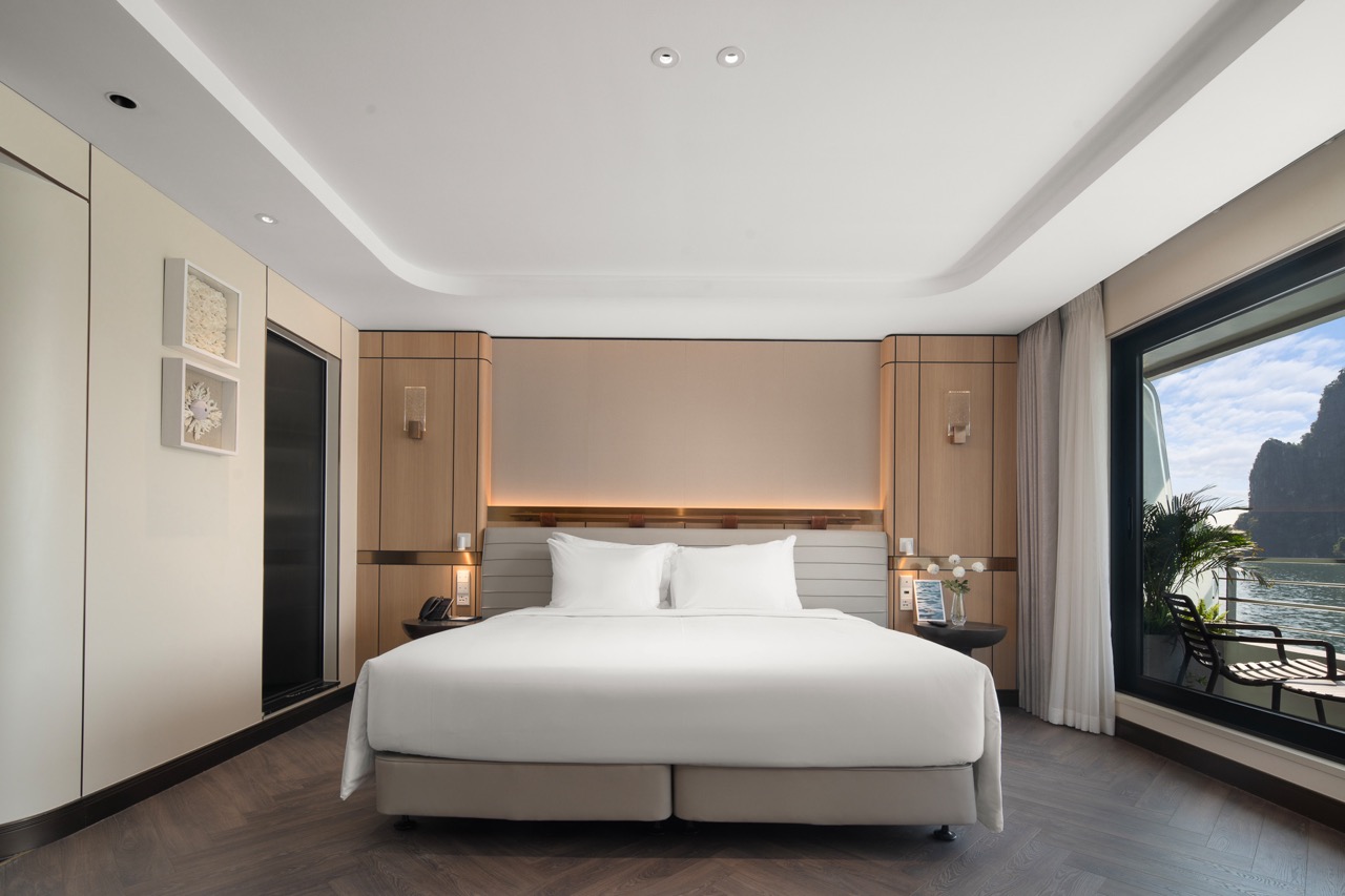 Luxurious hotel bedroom with modern decor and river view, perfect for relaxing stays in Vietnam.