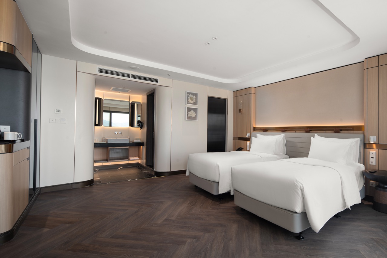 Modern hotel room with two beds, sleek interior design, and contemporary amenities – perfect for travelers.