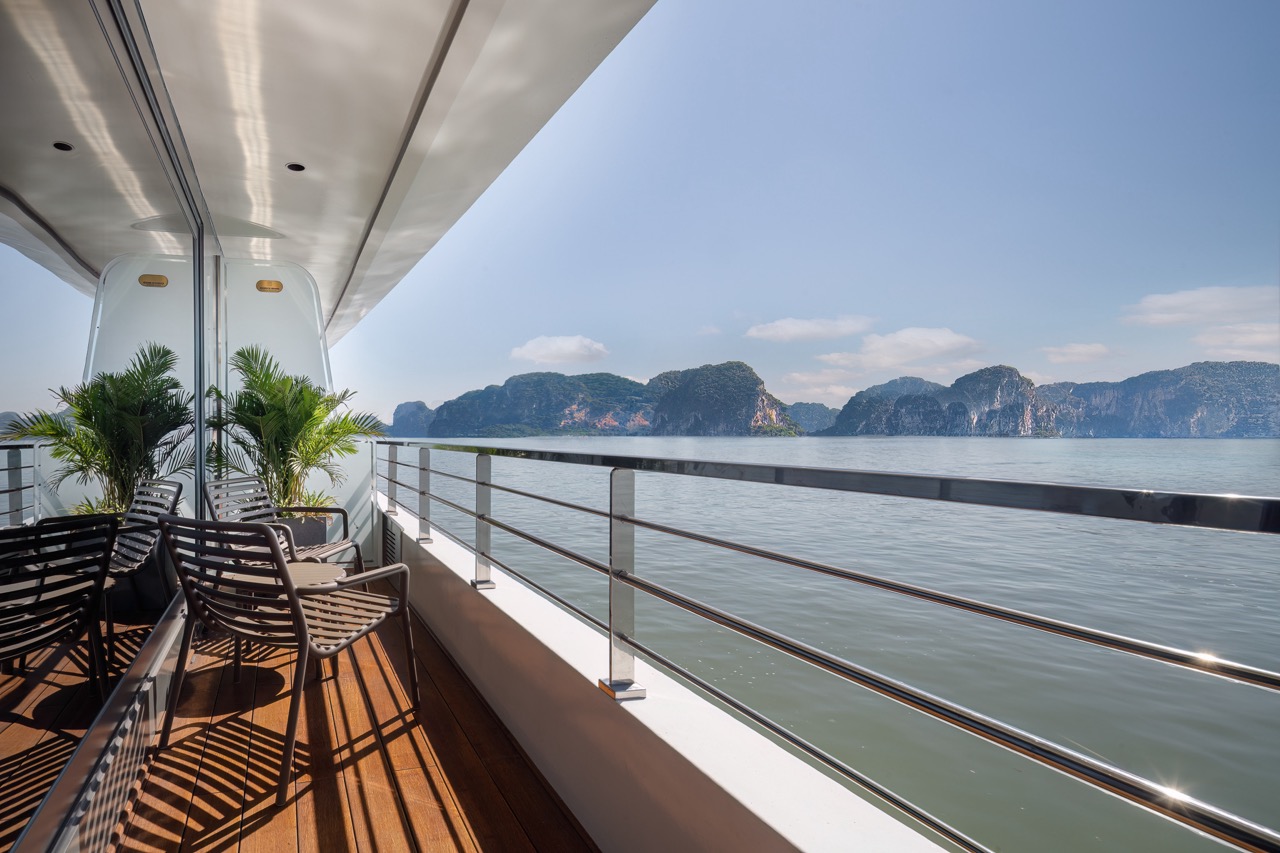 Luxury yacht balcony with scenic views of limestone karsts in Vietnam.