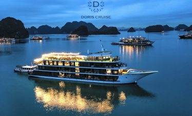 Stunning Halong Bay cruise ship at sunset with karst formations in the background.