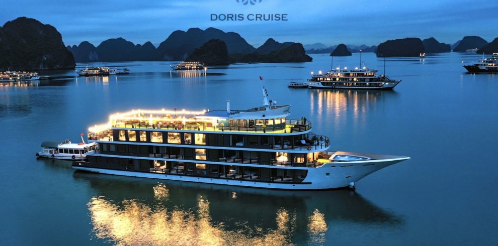 Stunning Halong Bay cruise ship at sunset with karst formations in the background.