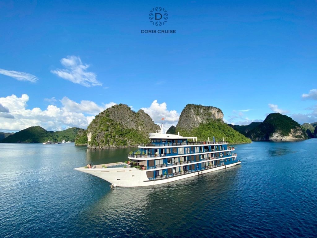Stunning view of Doris Cruise sailing through Halong Bay's emerald waters with limestone islands.