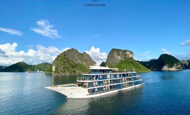 Stunning view of Doris Cruise sailing through Halong Bay's emerald waters with limestone islands.