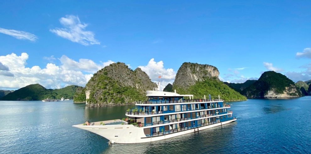 Stunning view of Doris Cruise sailing through Halong Bay's emerald waters with limestone islands.