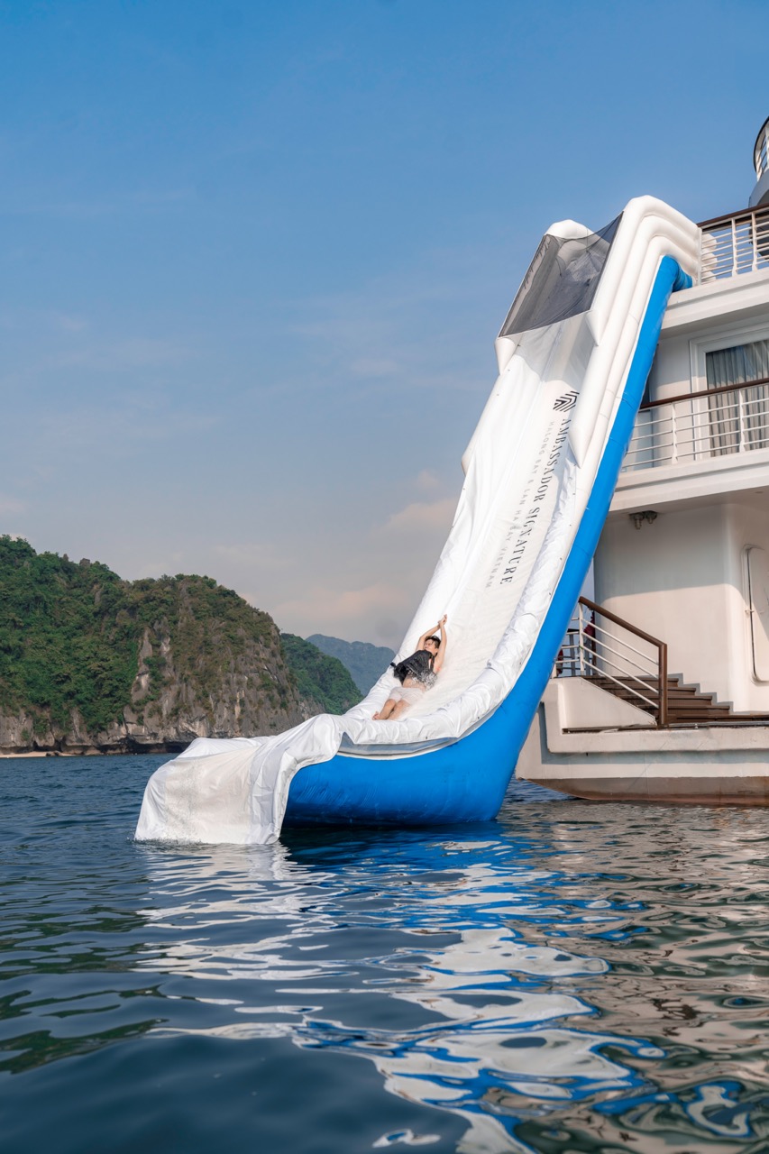 Luxury Halong Bay cruise balcony with water slide, scenic seascape, and relaxing atmosphere.