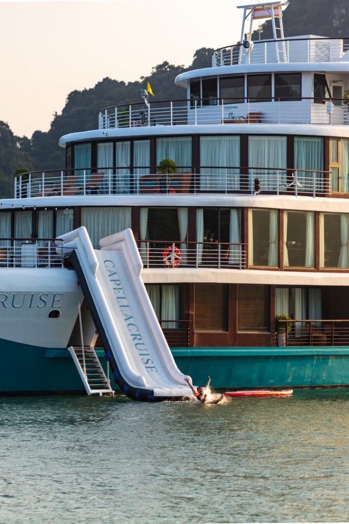 Luxury cruise yacht in Ha Long Bay, Vietnam with outdoor deck and water slide.