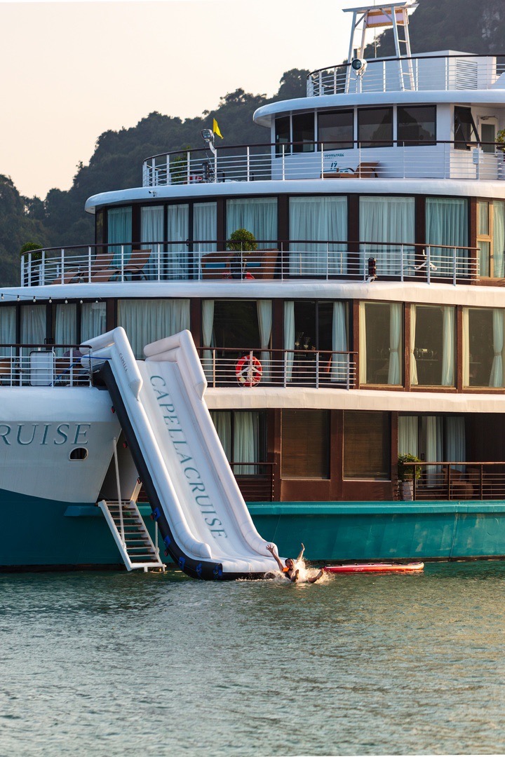 Luxury cruise yacht in Ha Long Bay, Vietnam with outdoor deck and water slide.