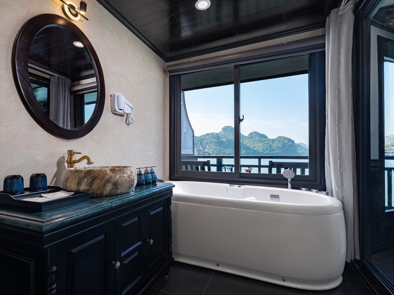 Luxurious cruise balcony overlooking Halong Bay with scenic mountain views.