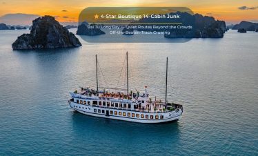 Elegant cruise ship sailing through tranquil Bai Tu Long Bay at sunset, showcasing luxury and scenic.