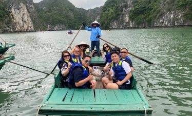 Boat tour in Halong Bay with tourists enjoying the scenic landscape and limestone karsts.